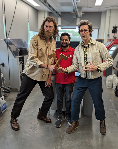 Rhett & Link stand on each side of ISE's Satya Konala, looking menacing with their peanut butter axes.