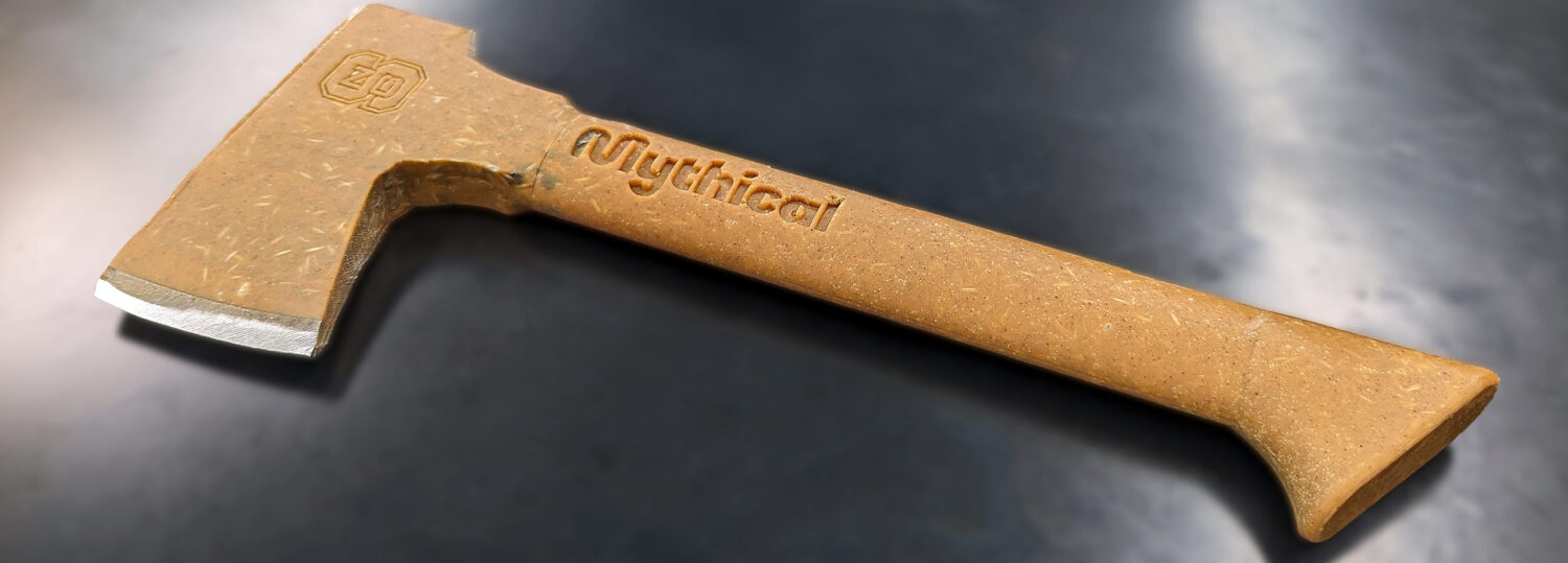 An axe constructed of peanut butter and epoxy lying on a table.